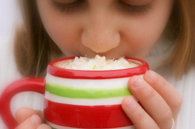 A girl sipping hot cocoa from a mug